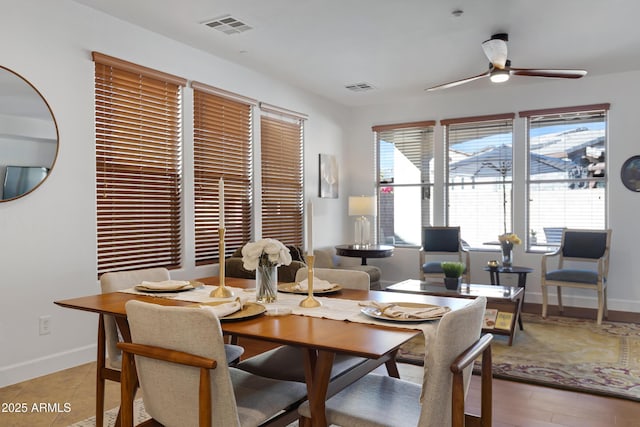 dining space featuring baseboards, a ceiling fan, and visible vents