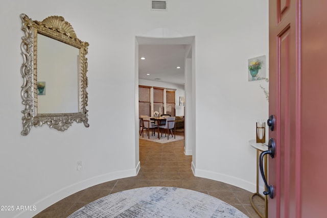 foyer entrance featuring dark tile patterned floors, visible vents, baseboards, and recessed lighting