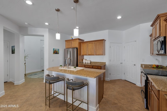 kitchen with stainless steel appliances, light stone counters, light tile patterned floors, and brown cabinets