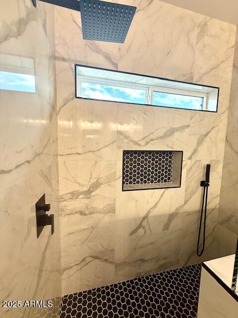 bathroom featuring a marble finish shower