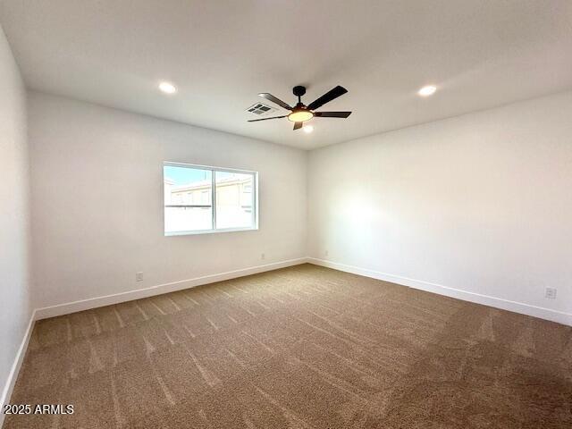 spare room featuring a ceiling fan, visible vents, baseboards, recessed lighting, and dark colored carpet