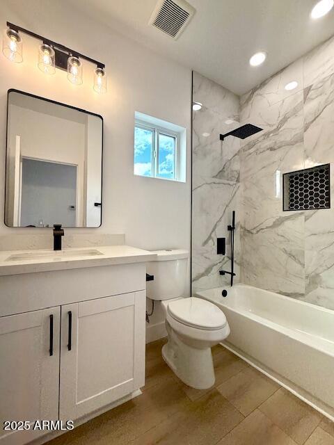 full bath with visible vents, baseboards, toilet, bathing tub / shower combination, and vanity