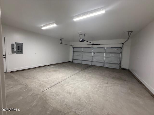 garage featuring electric panel, a garage door opener, and baseboards