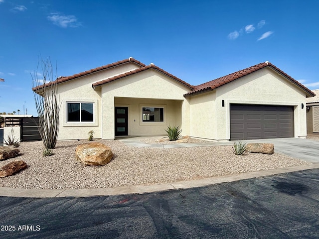 view of front of house with a tile roof, stucco siding, concrete driveway, and a garage