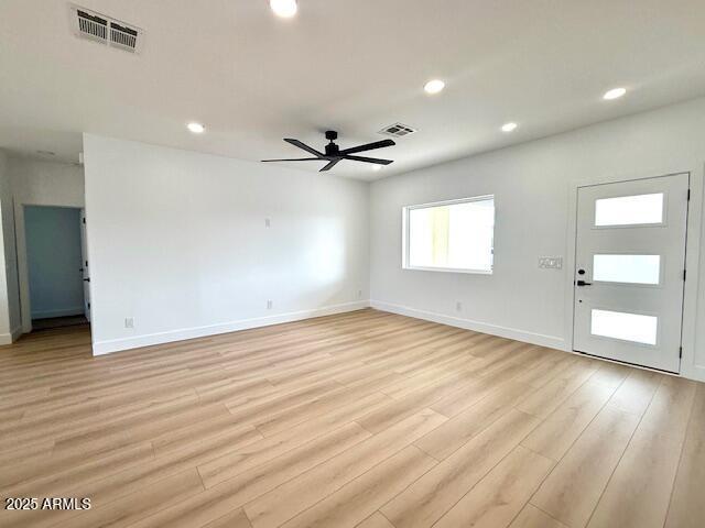 unfurnished living room with visible vents, a ceiling fan, and light wood finished floors