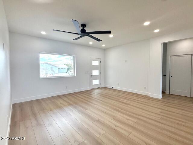 spare room featuring light wood finished floors, recessed lighting, a ceiling fan, and baseboards