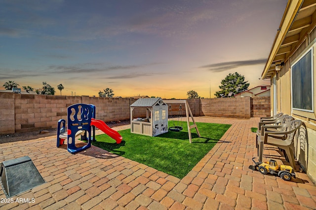 view of patio featuring a playground and a fenced backyard