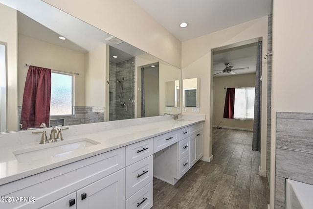 bathroom with ceiling fan, vanity, and a shower with door