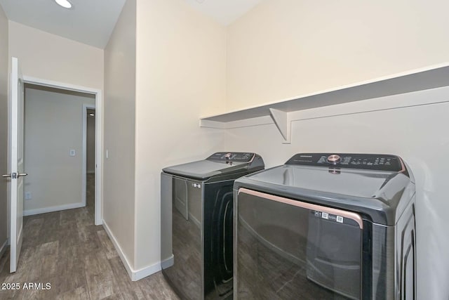 clothes washing area featuring dark wood-type flooring and independent washer and dryer