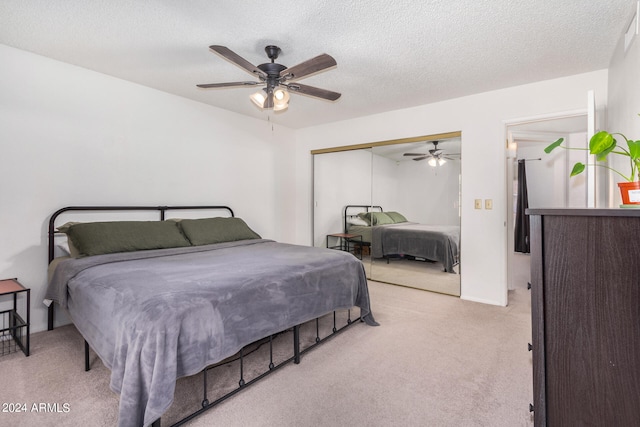 carpeted bedroom featuring a closet, ceiling fan, and a textured ceiling