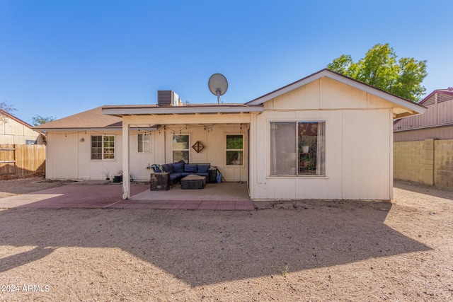 rear view of property with a patio, an outdoor living space, and ceiling fan