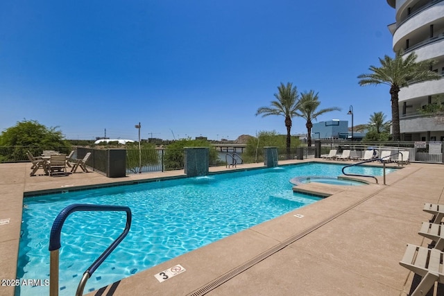 community pool with a patio area, a community hot tub, and fence