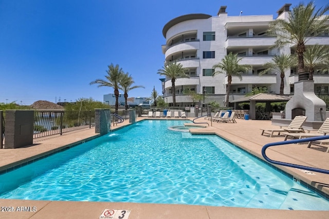 pool with fence and a patio area