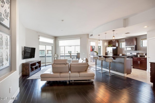 living area featuring recessed lighting, baseboards, and wood finished floors