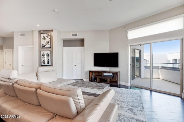 living area with baseboards and visible vents