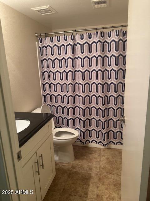 bathroom with vanity, tile patterned floors, toilet, and walk in shower