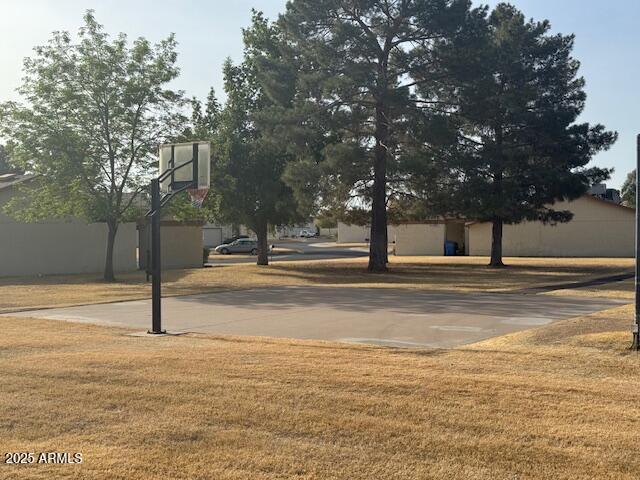 view of sport court featuring a yard