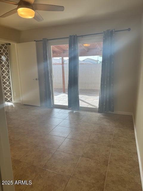 tiled spare room with plenty of natural light and ceiling fan