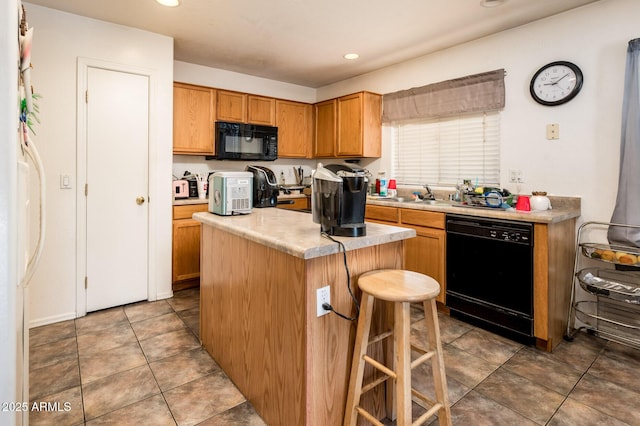 2721 N 107th Dr, Avondale, AZ 85392 - kitchen with black appliances, a kitchen island, a breakfast bar area, light countertops, and recessed lighting