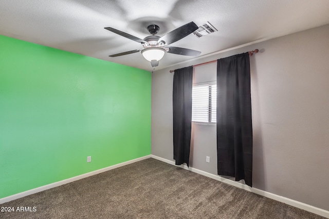 empty room featuring a textured ceiling, ceiling fan, and carpet floors