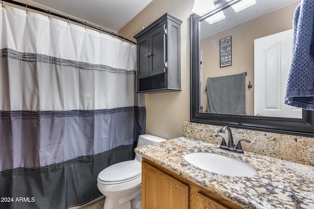 bathroom featuring toilet, vanity, a textured ceiling, and tile patterned floors