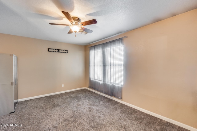 carpeted empty room featuring ceiling fan and a textured ceiling