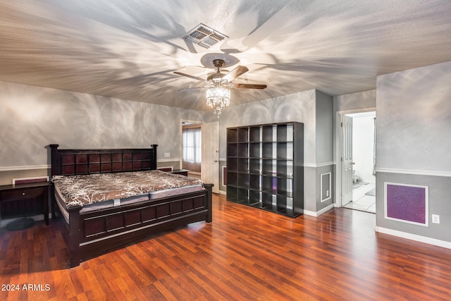 bedroom with ensuite bathroom, a textured ceiling, wood-type flooring, and ceiling fan