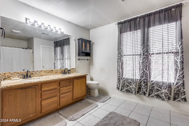 bathroom with vanity, tile patterned floors, toilet, and a textured ceiling