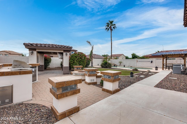 view of patio / terrace featuring area for grilling, central AC, a pool, and a gazebo