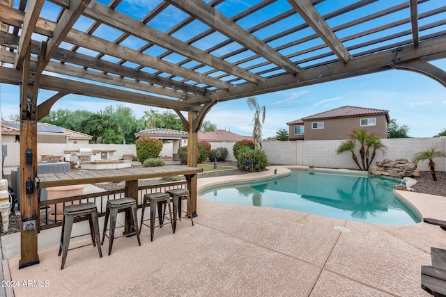 view of swimming pool featuring a patio area, exterior bar, and a pergola