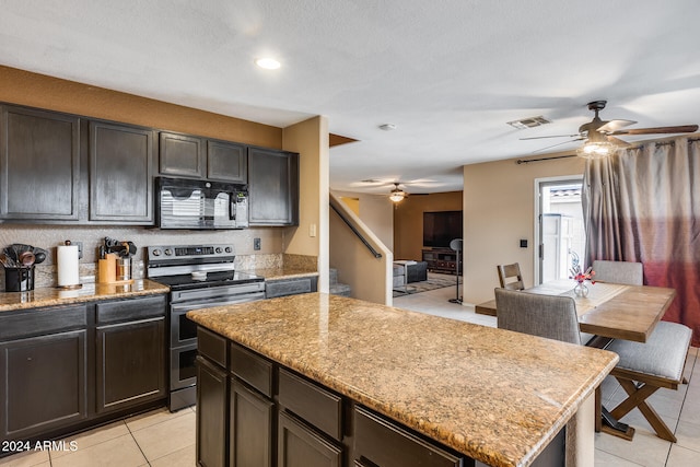 kitchen featuring dark brown cabinetry, a center island, stainless steel range with electric cooktop, and light stone countertops