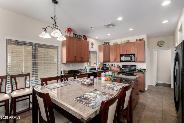 40904 N Hearst Dr, Anthem, AZ 85086 - kitchen featuring visible vents, a breakfast bar, black appliances, pendant lighting, and a center island