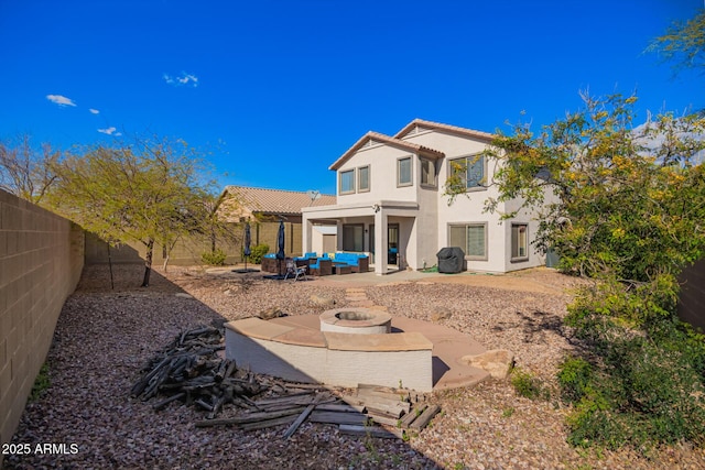 40904 N Hearst Dr, Anthem, AZ 85086 - rear view of property featuring stucco siding, a tiled roof, a fenced backyard, an outdoor living space with a fire pit, and a patio area