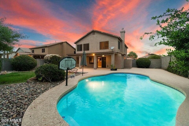 pool at dusk with a patio