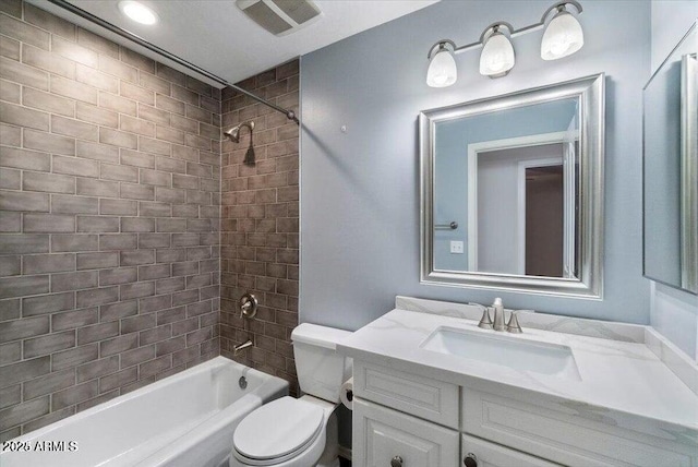 full bathroom with tiled shower / bath, vanity, and toilet