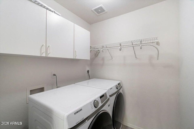 laundry room featuring washing machine and dryer and cabinets