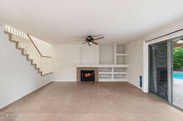 unfurnished living room with light tile patterned flooring, ceiling fan, and built in shelves