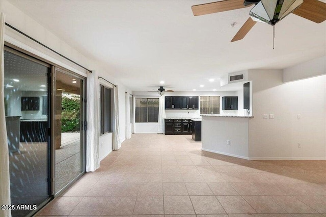 unfurnished living room featuring light tile patterned floors and ceiling fan