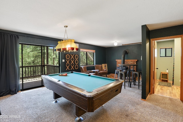 rec room featuring a wood stove, light carpet, and billiards