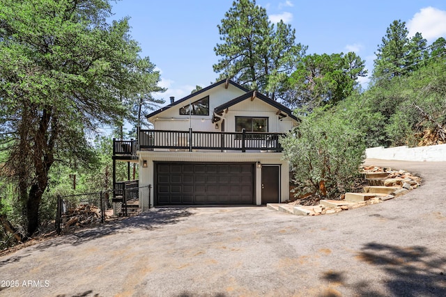 chalet / cabin featuring an attached garage and driveway