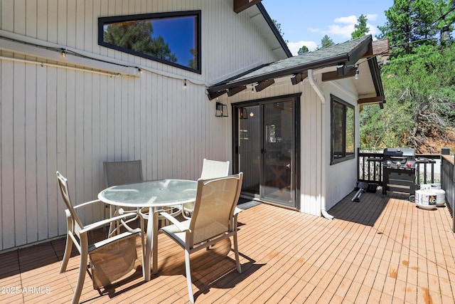 deck with outdoor dining area and area for grilling