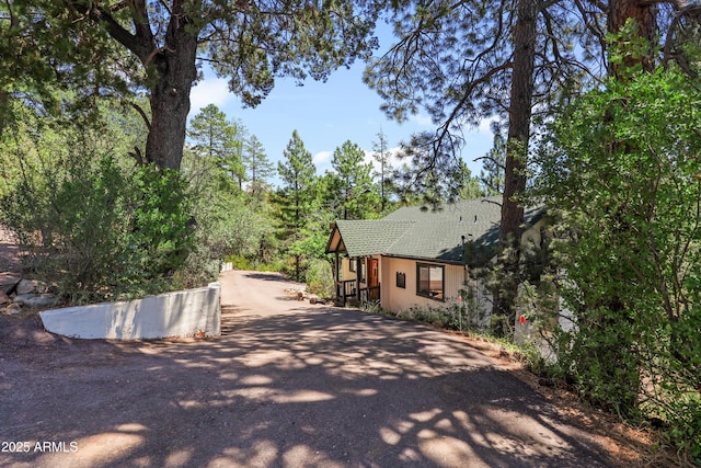 view of home's exterior with driveway, a shingled roof, and stucco siding