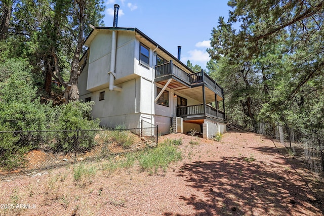 exterior space featuring a balcony and fence