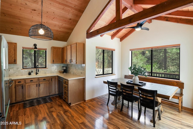 kitchen with light countertops, hanging light fixtures, backsplash, and a sink