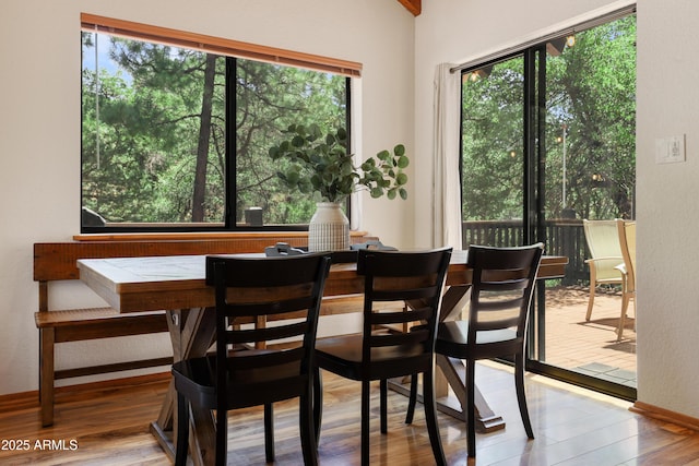 dining area with a wealth of natural light, baseboards, and light wood finished floors