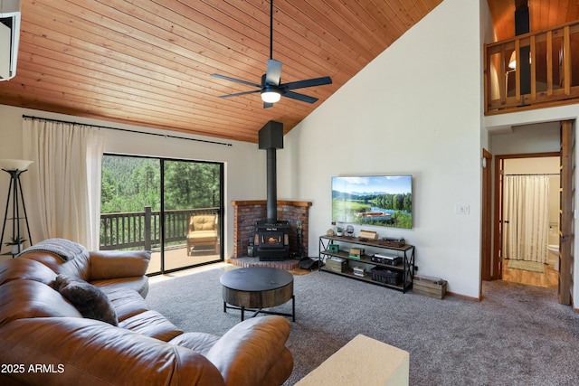 living room with wooden ceiling, ceiling fan, a wood stove, carpet flooring, and high vaulted ceiling