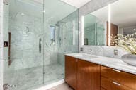 full bath with a stall shower and double vanity