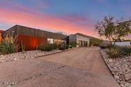mid-century modern home featuring asphalt driveway and a garage