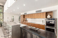 kitchen featuring double oven, brown cabinets, and recessed lighting
