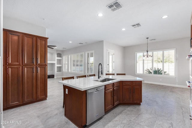 kitchen featuring stainless steel dishwasher, ceiling fan with notable chandelier, a kitchen island with sink, sink, and pendant lighting